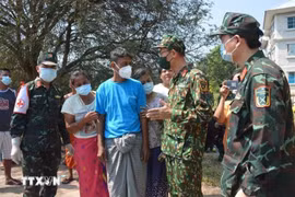 Personnel from the Vietnam People’s Army talk to Myanmar people about search and rescue efforts after the eathquake. (Photo published by VNA)