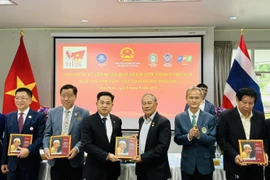Overseas Vietnamese receive bilingual book “President Ho Chi Minh in Thailand”. (Photo: VNA)