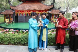 Madam Ngo Phuong Ly (L) presents a water puppet to Madam Loo Tze Lui. (Photo: VNA)