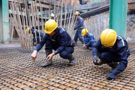 Workers on the construction site of a bridge over the Red River in the border area between Lao Cai and China's Yunnan province. (Photo: VNS/VNA)