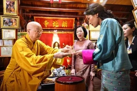 Most Venerable Thich Thanh Nha, Abbot of Tran Quoc Pagoda, presents a Bodhi leaf to Nguyen Thi Minh Nguyet, spouse of State President Luong Cuong, and Bhutanese Queen Jetsun Pema Wangchuck. (Photo: VNA)