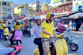 Tourists enjoy exploring Ho Chi Minh City by Vespa. (Photo: VNA)