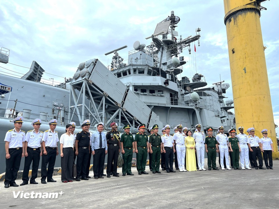 Delegates pose for photos in front of the guided-missile destroyer INS Delhi. (Photo: VietnamPlus)