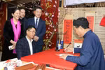 Tourists ask for a calligraphy at a stall in the traditional Tet market in Hoa Lu old quarter. (Photo: VNA)