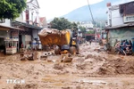 Excavators are deployed to help clear mud, fallen branches, and debris swept in by recent floods in Song Ma commune, Son La province. (Photo: VNA)