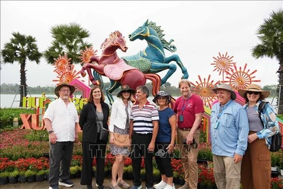 Foreign visitors check-in with the horse mascot besides the Huong River, Hue city, ahead of the Lunar New Year 2026 – the Year of the Horse. (Photo: VNA)