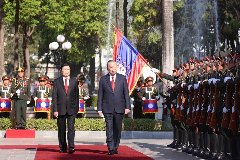 Party General Secretary To Lam (R) and Lao Party General Secretary and President Thongloun Sisoulith review the guard of honour of the Lao People’s Army. (Photo: VNA) 