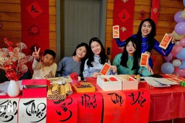 A calligraphy booth draws young Vietnamese at the gathering. (Photo: VNA)