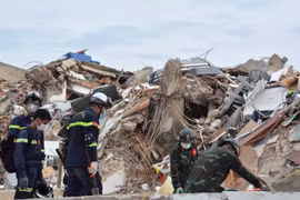 Vietnamese rescuers search for victims trapped beneath the rubble. (Photo published by VNA)
