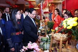 Prime Minister Pham Minh Chinh and his spouse visits a Tet booth of the Vietnamese community at the event (Photo: VNA)