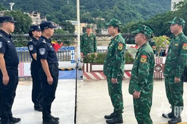 Before the patrol, the Lao Cai and Chinese commands met at the demarcation line at the Lao Cai international border gate to exchange information. (Photo: qdnd.vn)