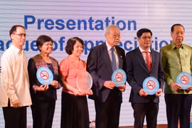 Delegates receive the tokens of the conference. (Photo: VNA)