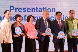 Delegates receive the tokens of the conference. (Photo: VNA)