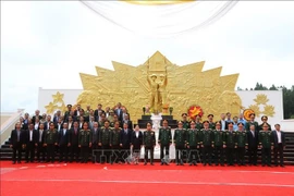 Delegates pose for a group photo at the Vietnam-Laos combat alliance monument in the southern Lao province of Champasak on July 1. (Photo: VNA)