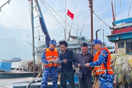 The crew of Coast Guard vessel CSB 1011 disseminate information to raise fishermen’s awareness about IUU fishing. (Photo: Vietnam Coast Guard)
