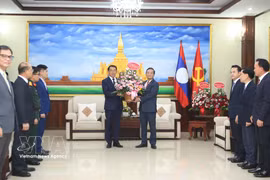 Ambassador Nguyen Minh Tam presents Party General Secretary To Lam's flowers to the LPRP Central Committee's External Relations Commission to congratulate on the LPRP's 71st founding anniversary. (Photo: VNA) 
