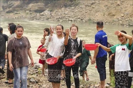 Young Lao ethnic women splash water to pray for good fortune during the traditional water-splashing New Year festival. (Photo: VNA)