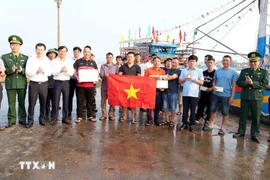 Vice Chairman of the Quang Tri provincial People’s Committee Le Van Bao (top row, fourth from right) presents gifts to fishermen and calls for strict compliance with regulations on IUU fishing. (Photo: VNA)