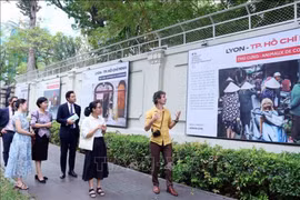 Adrien Jean (right) introduces his photos at the exhibition (Photo: VNA)