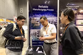Domestic and foreign businesses connect at an exhibition booth. (Photo: VNA)
