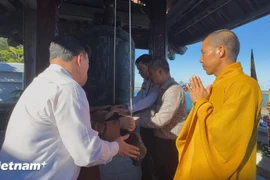 Passengers aboard the “Great Solidarity Ship” ring the bell at Da Tay A Pagoda (Photo: VietnamPlus)