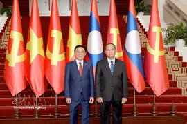 Politburo member and Permanent member of the Communist Party of Vietnam Central Committee’s Secretariat Tran Cam Tu and his Lao counterpart Vilay Lakhamphong, pose for a photo at their meeting in Vientiane on April 9. (Photo: VNA)