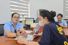 A civil servant in Mao Khe ward, Quang Ninh province, guides a resident in submitting notarisation applications via the National Public Service Portal. (Photo: VNA)