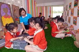 A teacher and children at Tran Cao Kindergarten in Quang Hung commune, Hung Yen province, take part in experiential learning activities. (Photo: VNA)