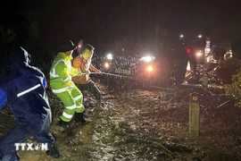 Traffic Police support people and vehicles passing through a landslide section on National Highway 7A in central province of Nghe An. (Photo: VNA)