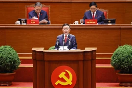Politburo member and Standing member of the Party Central Committee’s Secretariat Tran Cam Tu presents a report reviewing the leadership and direction of the 13th Party Central Committee (Photo: VNA)