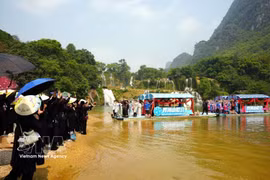 Vietnamese and Chinese artists perform traditional duet singing on the river at the Ban Gioc (Vietnam) – Detian (China) Waterfalls on April 13. (Photo: VNA)