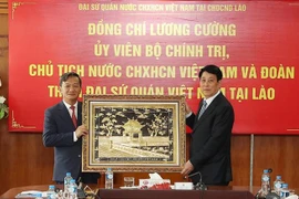 State President Luong Cuong presents a painting of Khue Van Cac (Constellation of Literature Pavilion) - part of The Temple of Literature to the Vietnamese Embassy in Laos. (Photo: VNA)