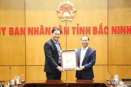 Vice Chairman of the Bac Ninh provincial People’s Committee Mai Son (right) presents a Dong Ho folk painting to Singapore Semiconductor Industry Association Executive Director Ang Wee Seng (Photo: baobacninhtv.vn)