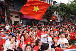 People happily welcome the forces joining in a rehearsal for the National Day parade. (Photo: VNA)