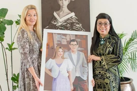 Vietnamese PM’s spouse (R) presents a mosaic to Estonian PM’s wife. (Photo: VNA)