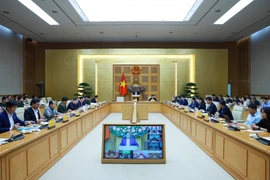 Prime Minister Pham Minh Chinh (centre) chairs a hybrid meeting meeting with ministries, central agencies and local authorities on December 17 to review the implementation of the “Quang Trung Campaign” to rebuild and repair homes that are severely damaged by recent storms and floods. (Photo: VNA)