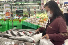 A consumer chooses seafood products at a supermarket (Photo: VNA)