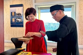 President of the UNESCO General Conference Simona-Mirela Miculescu crafts her own piece of Dong Ho painting. (Photo: VNA)