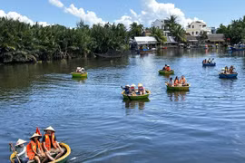 Tourists experience bamboo basket boat tours in Bay Mau nipa palm forest (Photo: VNA)