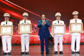 Prime Minister Pham Minh Chinh (middle) presents the Hero of the People’s Armed Forces title to outstanding individuals and collectives of the the People’s Public Security force. (Photo: VNA)