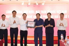 Politburo member Phan Dinh Trac hands over assistance from Party, State and Vietnam Fatherland Front leaders to people of the central province of Nghe An (Photo: VNA)