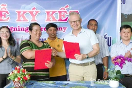 Thi Khui, Director of Bu Lach Organic Cashew Cooperative, signs a cashew purchasing cooperation agreement with a representative of Intersnack Vietnam Cashew Company Limited. (Photo: Dong Nai Newspaper)
