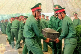 Remains of seven Vietnamese volunteer soldiers and experts who sacrificed in Laos during wartime are reburied at Tong Khao Martyrs’ Cemetery in Thanh Nua commune, Dien Bien district in the northern province of Dien Bien. (Photo: VNA)