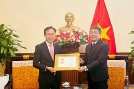 Permanent Deputy Minister of Foreign Affairs Nguyen Minh Vu (right) awards the For the Cause of Vietnam’s Foreign Affairs insignia to General Director of Samsung Vietnam Choi Joo Ho on February 13. (Photo: VNA)