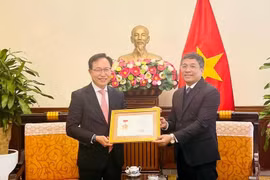 Permanent Deputy Minister of Foreign Affairs Nguyen Minh Vu (right) awards the For the Cause of Vietnam’s Foreign Affairs insignia to General Director of Samsung Vietnam Choi Joo Ho on February 13. (Photo: VNA)
