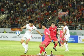 A Vietnamese national team player handles the ball in Laos’s penalty area. (Photo: VNA)