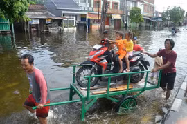 People evacuate from flooded areas after heavy rains in Semarang, Central Java, Indonesia. (Photo: Xinhua/VNA)