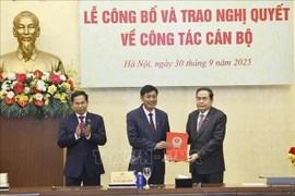 NA Chairman Tran Thanh Man (first, right) presents the resolution appointing Nguyen Huu Dong, member of the Party Central Committee and deputy head of the Party Central Committee’s Commission for Internal Affairs, as Permanent Vice Chairman of the 15th NA’s Committee for Deputy Affairs. (Photo: VNA)