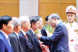 Party General Secretary To Lam presents the badges marking 80, 75, 60, 55, 50, 45, and 40-year Party membership to the veteran revolutionaries at the meeting. (Photo: VNA)