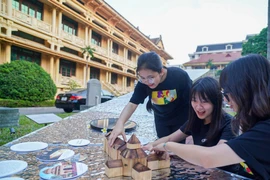 Young people interact with artworks at the Vietnam National Museum of History during the 2024 Hanoi Creative Design Festival. (Photo: VNA)